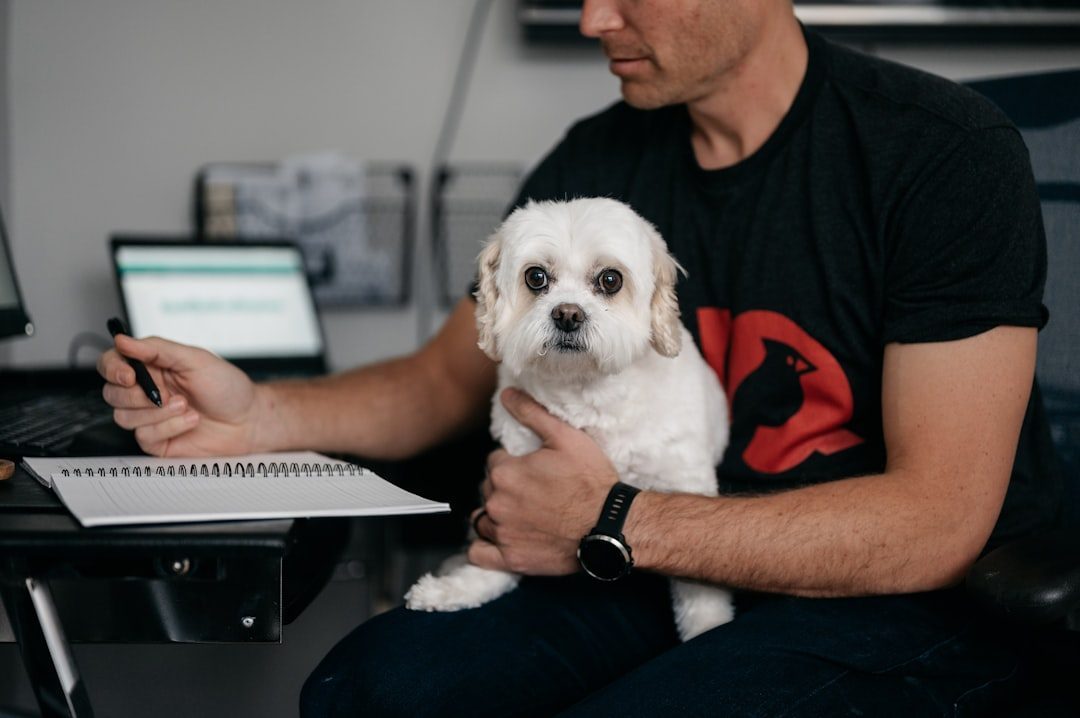 Person filling out an adoption application on a clipboard next to a dog